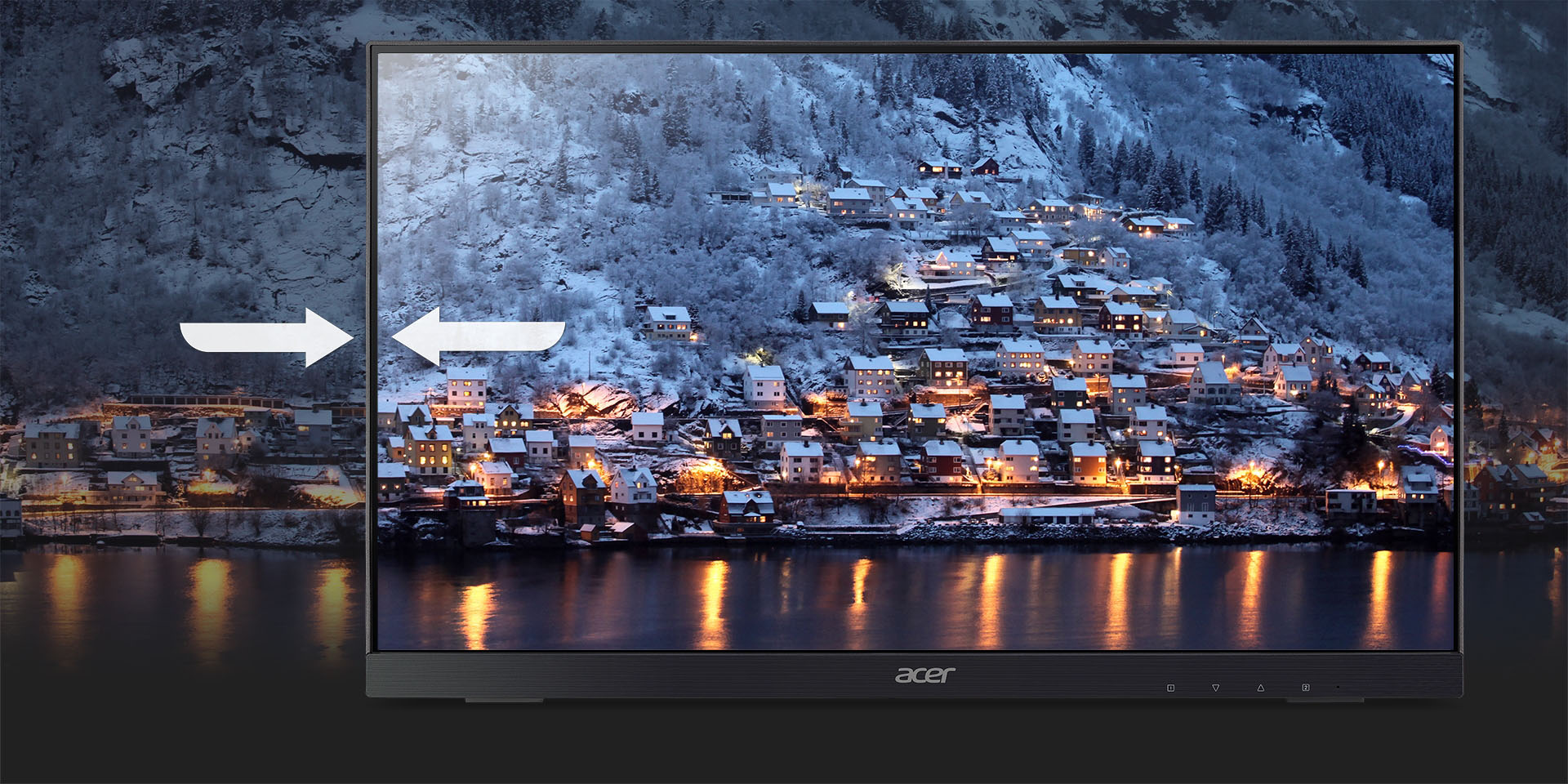 A UT2 monitor with ZeroFrame frames a background of a town sitting at the feet of a snowy mountain with a lake in front.